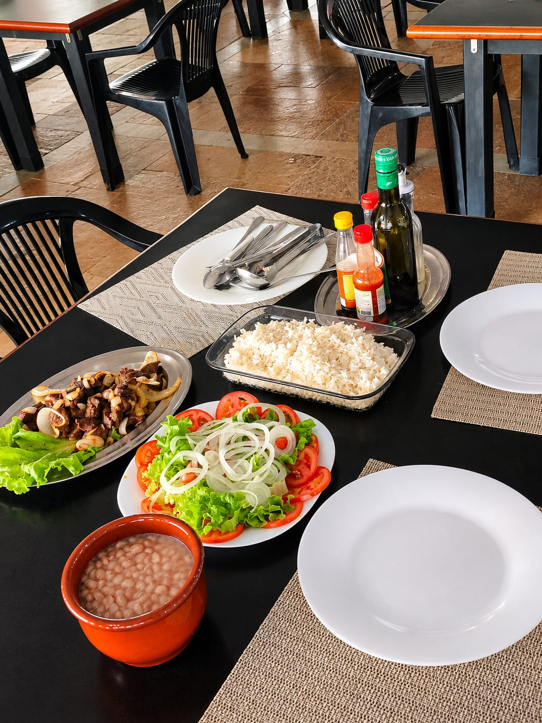 Mesa servida no BIMA com arroz, feijão, salada e carne acebolada
